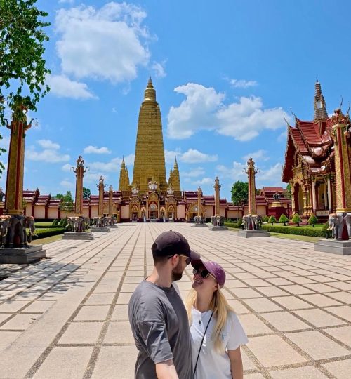 Ein glückliches Paar vor einem Tempel in Thailand